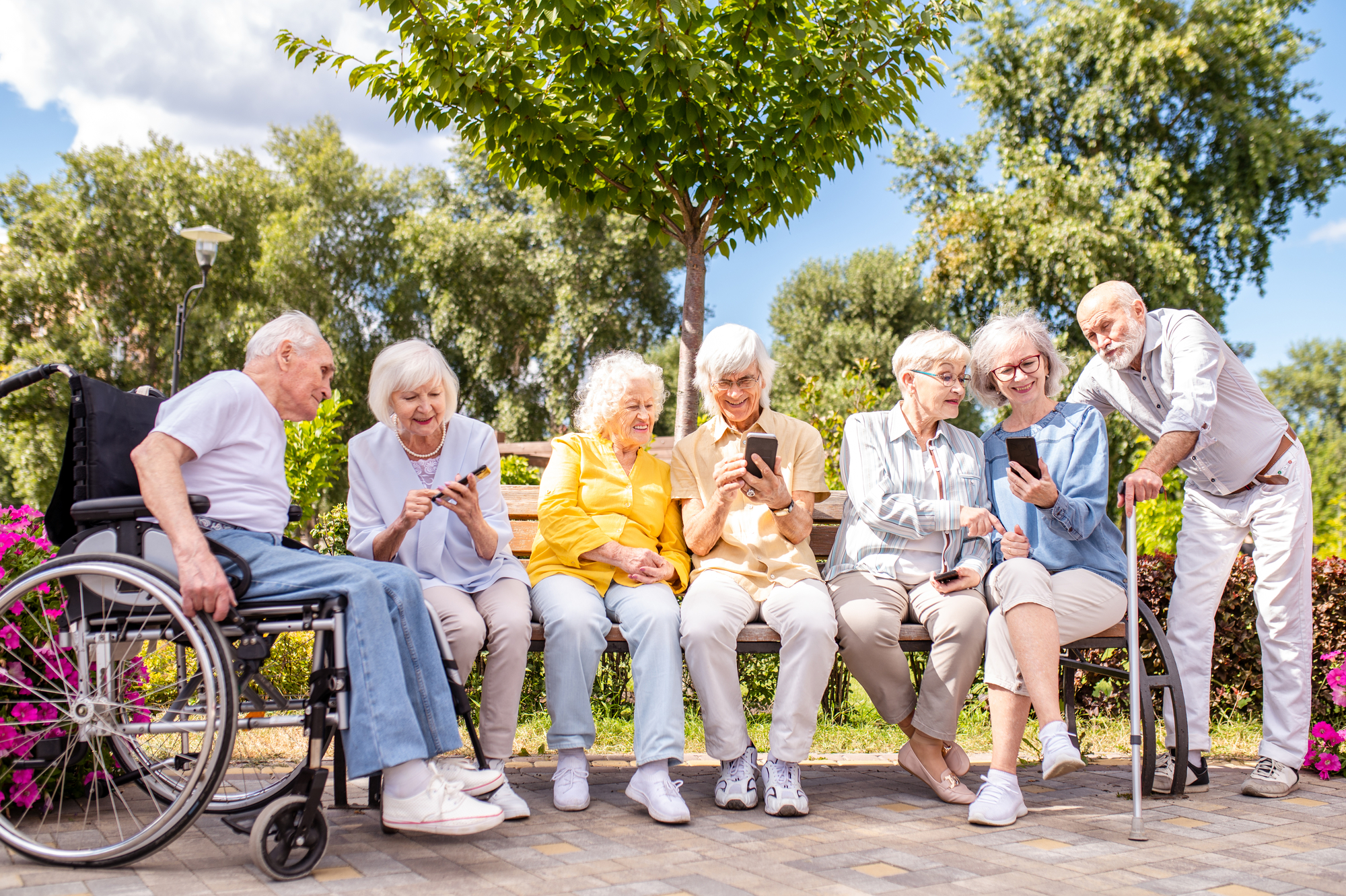 Group of happy elderly people bonding outdoors at the park - Old people in the age of 60, 70, 80 having fun and spending time together, concepts about elderly, seniority and wellness aging